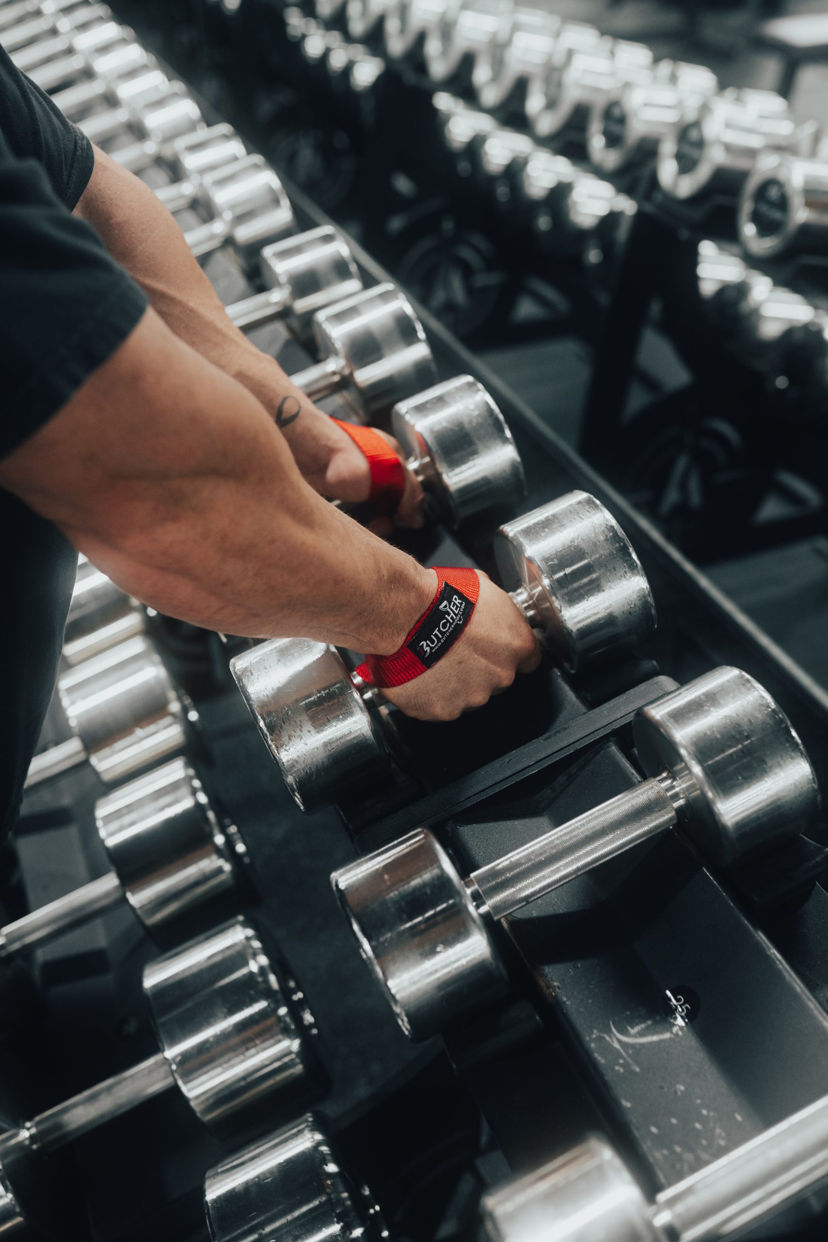 Lifter using Butcher Hooks on a dumbbell rack